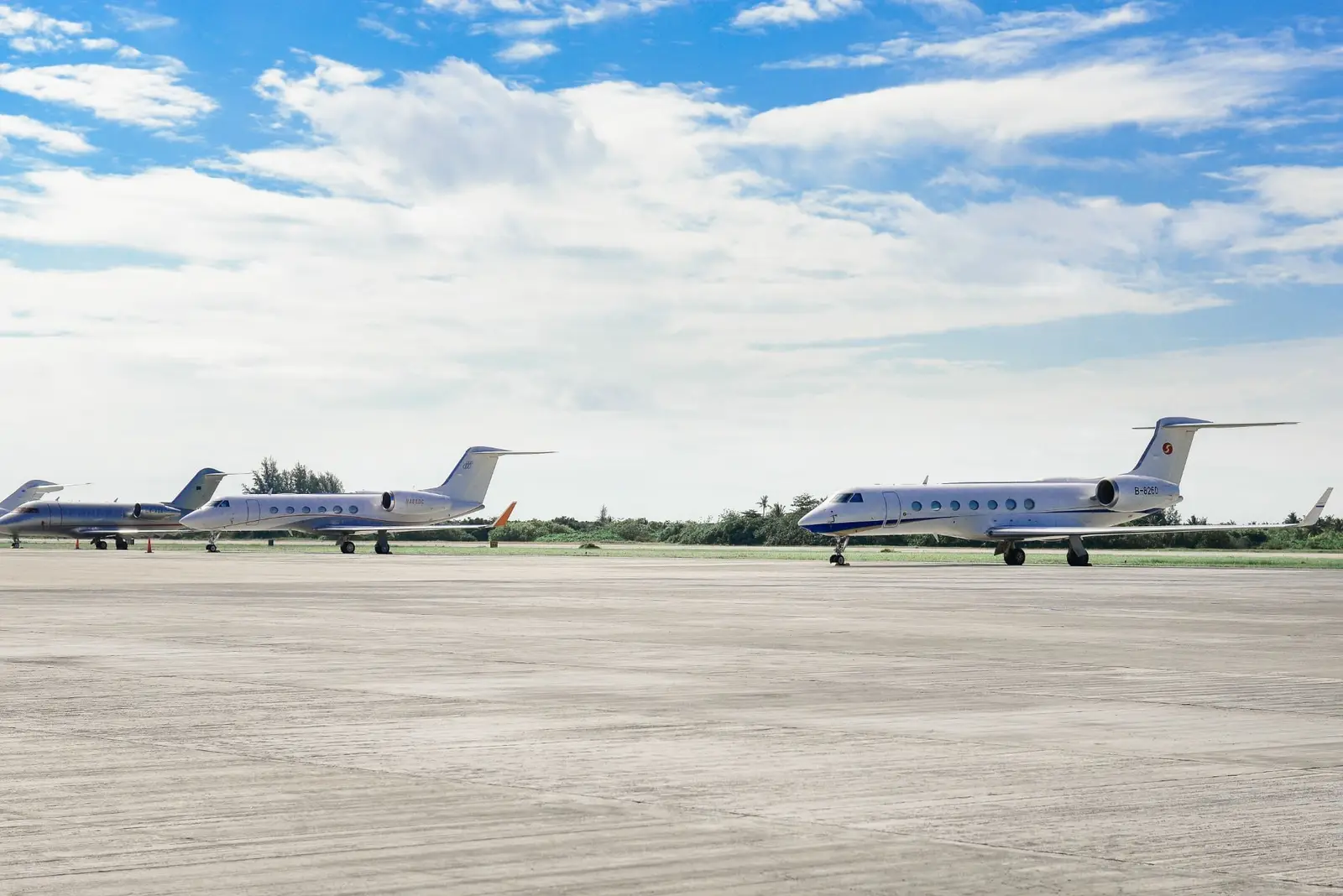 Jets parked on an airport ramp under a blue sky